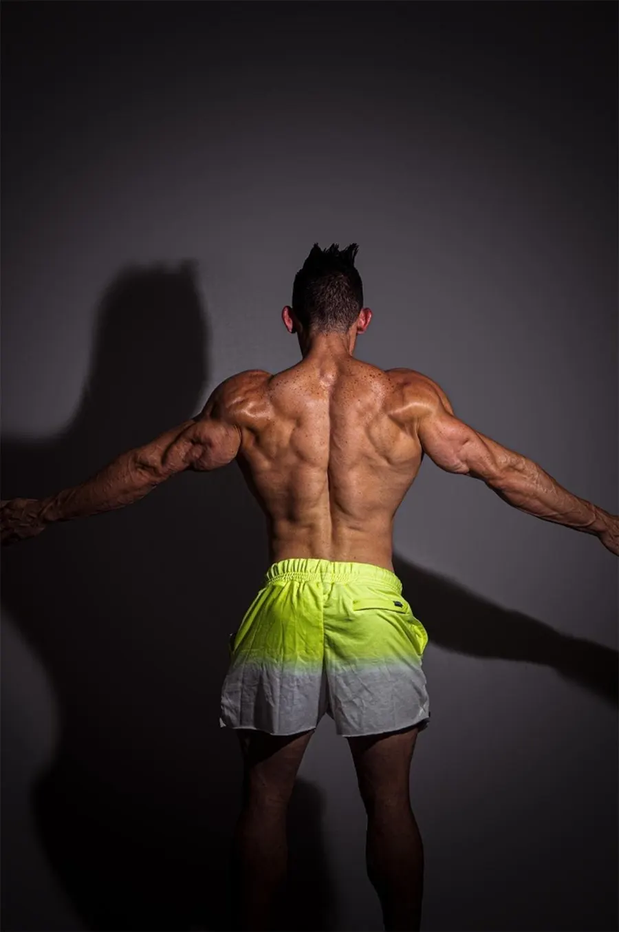 Robert de espaldas con los brazos extendidos mostrando la espalda ancha